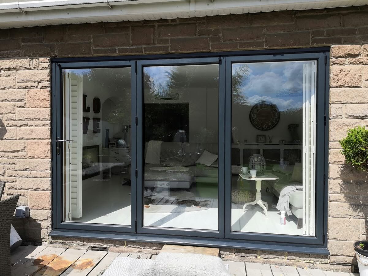 Anthracite grey three panel bifold doors fitted to a stone house in Sheffield