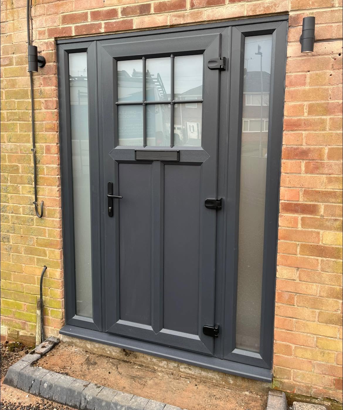 Anthracite grey stable style door fitted into a stone wall