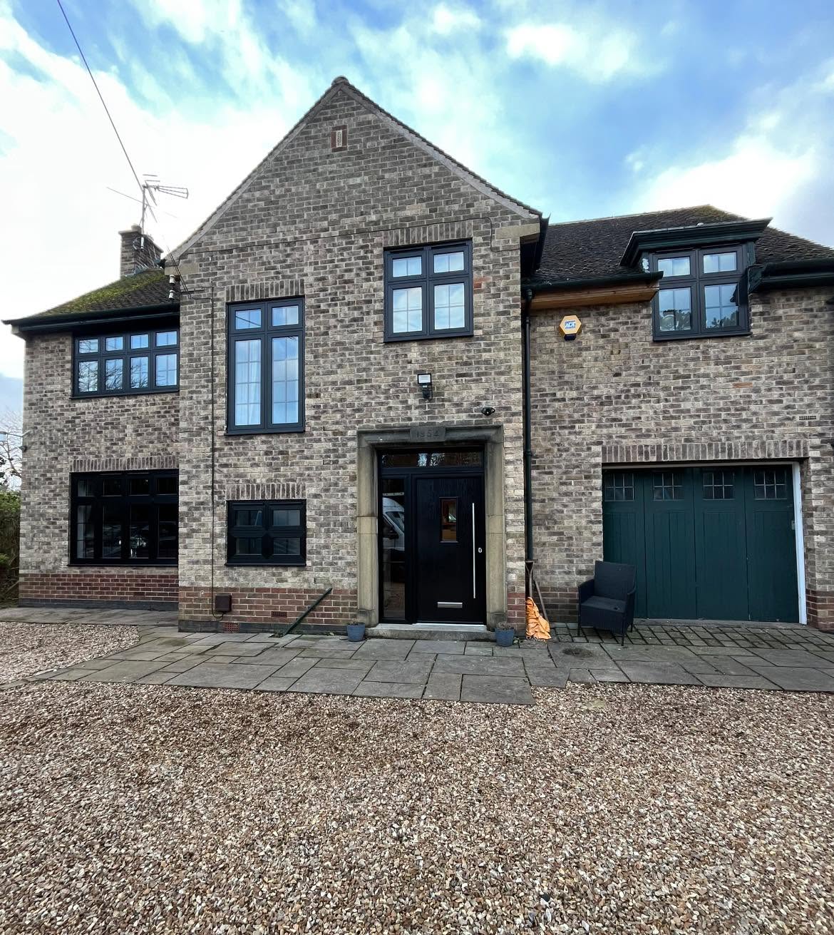 Stone fronted house with anthracite grey windows throughout and a matching garage door
